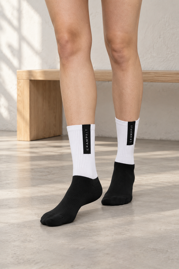 CRAMPFIT black and white crew socks, close front view showing ribbed legs and black feet.