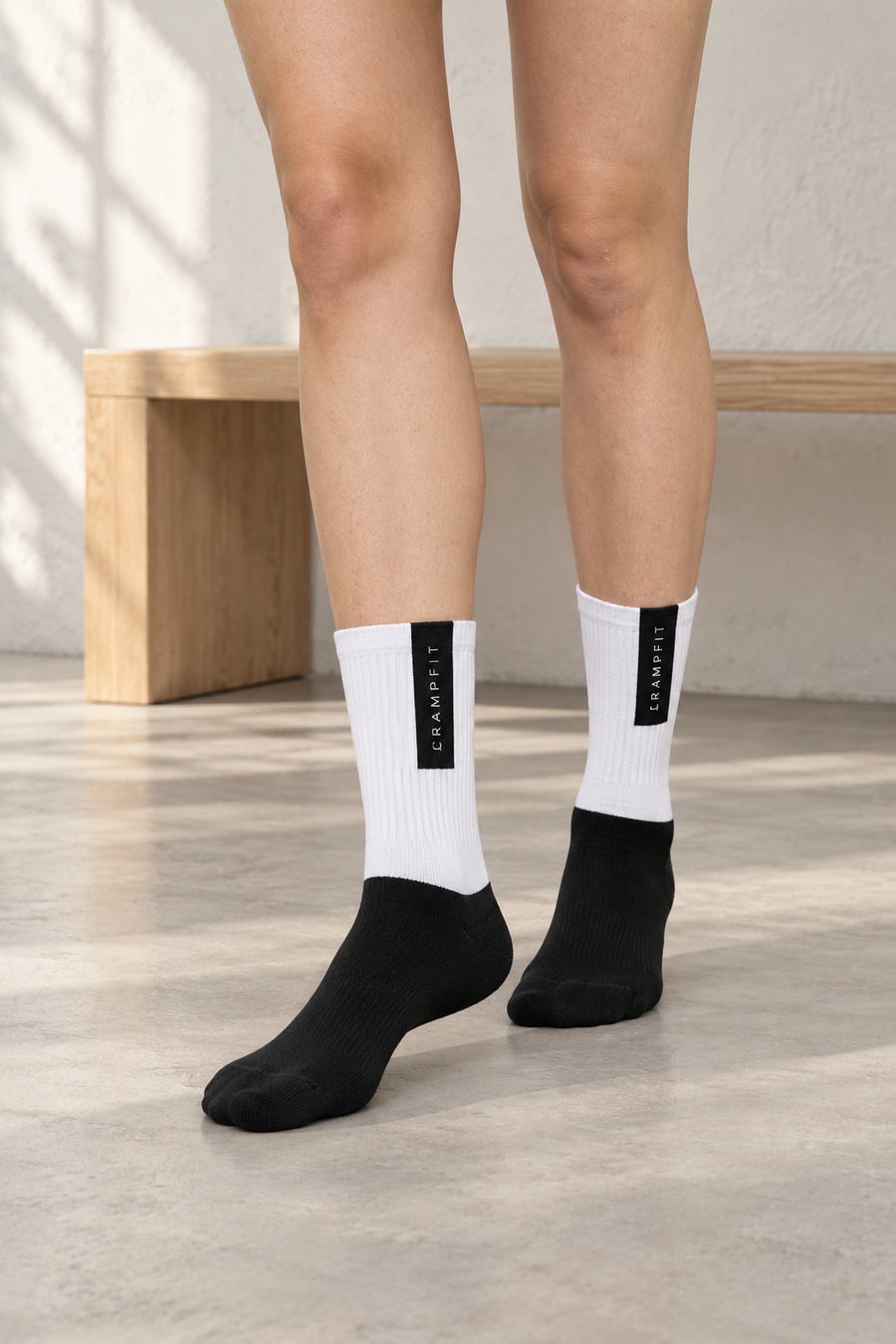 CRAMPFIT black and white crew socks, close front view showing ribbed legs and black feet.