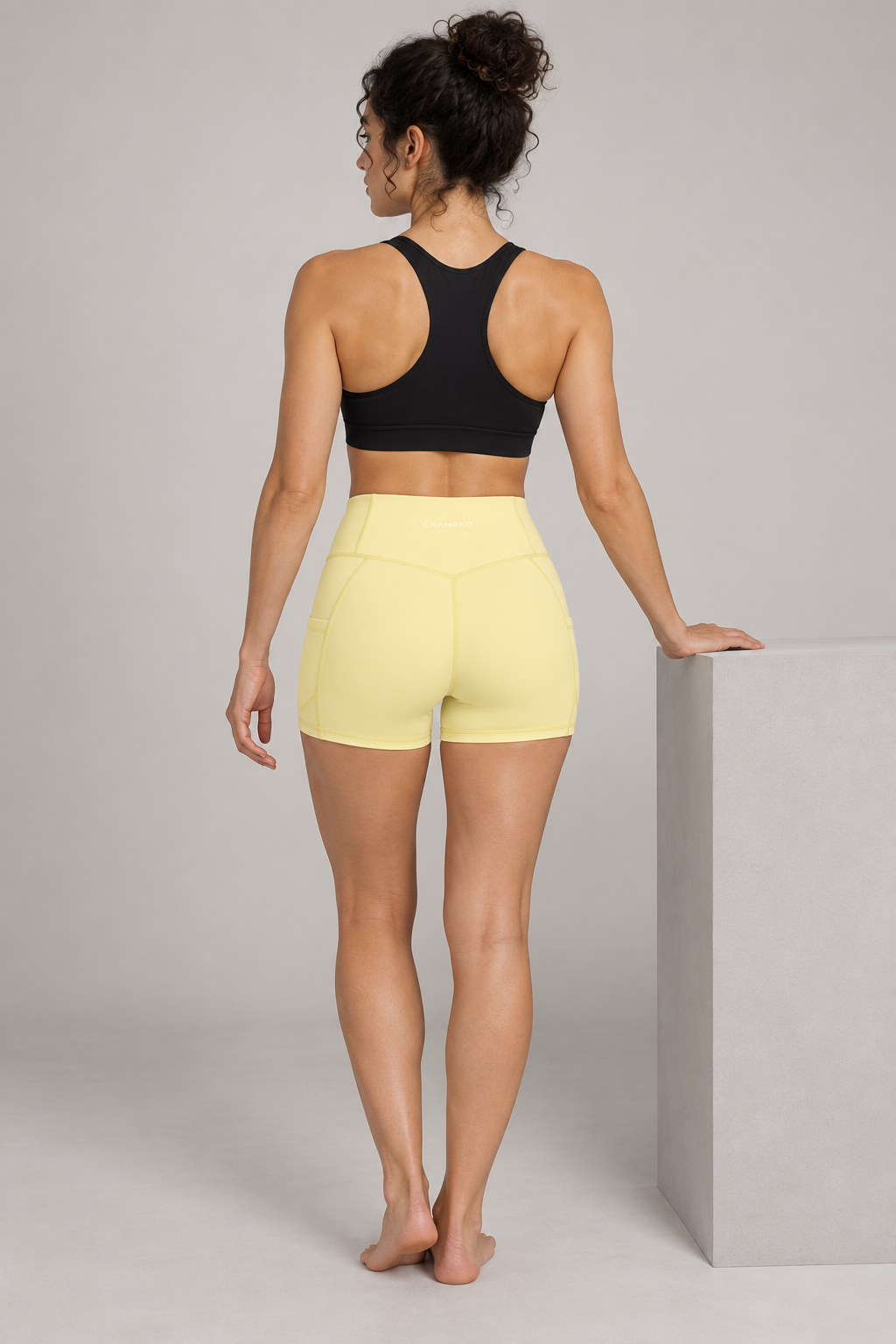CRAMPFIT Women's High Rise Pocket Yoga Shorts - Yellow - Back view on model