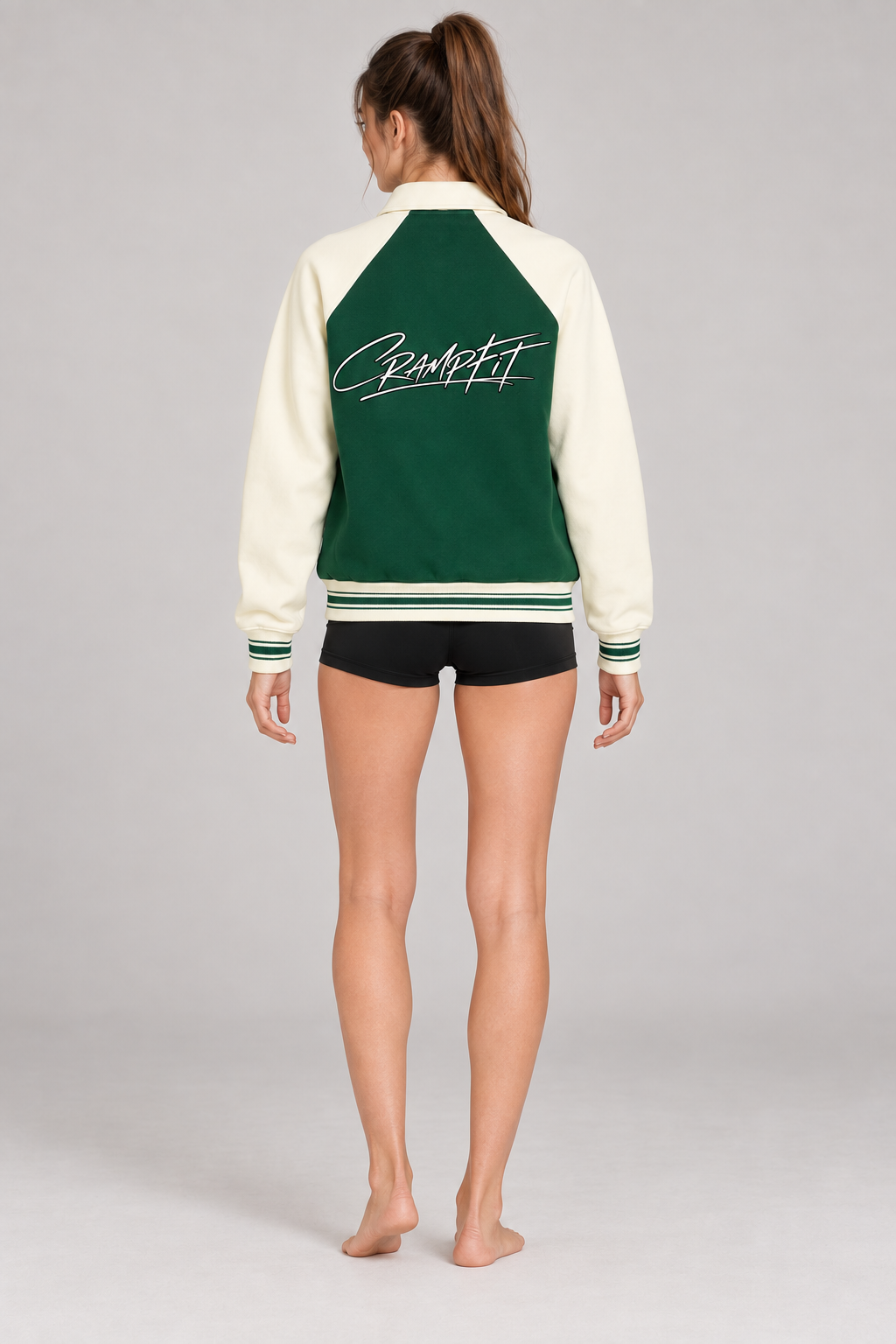 CRAMPFIT Raglan Varsity Jacket in green and cream, back logo view on a slim female model