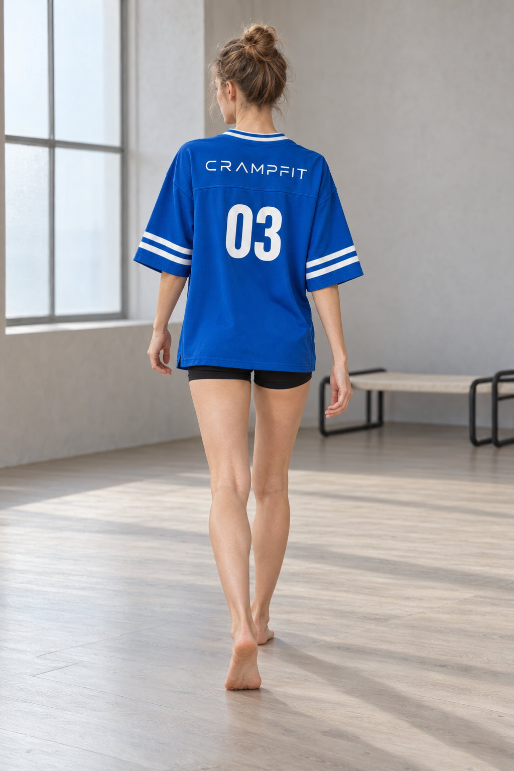 CRAMPFIT women's blue boxy jersey, full-body back view showing CRAMPFIT lettering and number 03.