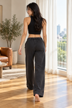 CRAMPFIT washed black wide-leg sweatpants, rear view showing the relaxed fit and open hems.