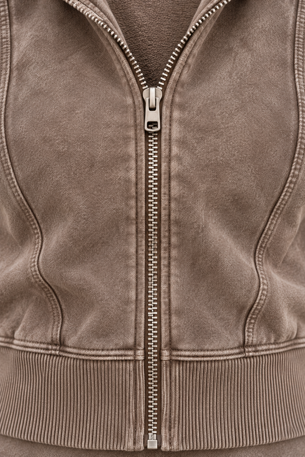 Close-up of CRAMPFIT espresso crop hoodie showing metal zipper, washed fleece, shaping seams and ribbed hem.