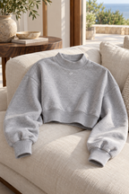 Heather gray CRAMPFIT cropped mock neck sweatshirt on a linen chair, showing fabric texture, CF logo and ribbed collar, cuffs and hem.