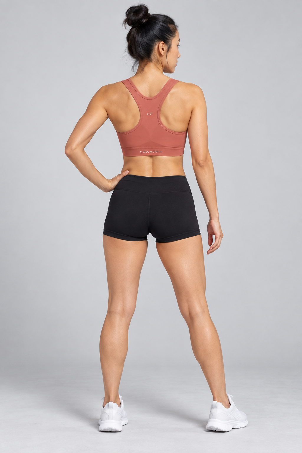 CRAMPFIT Women's Cropped Sports Bra - brick red back view with black workout shorts