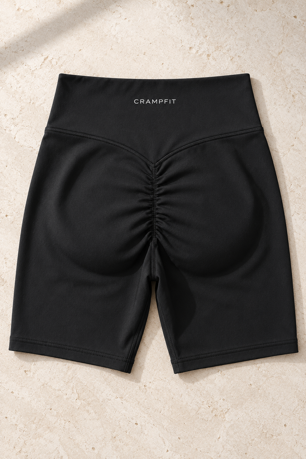 CRAMPFIT women's high-waist yoga biker shorts in black, flat-lay detail of the waistband, stitching and ruched back.