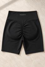 CRAMPFIT women's high-waist yoga biker shorts in black, flat-lay detail of the waistband, stitching and ruched back.