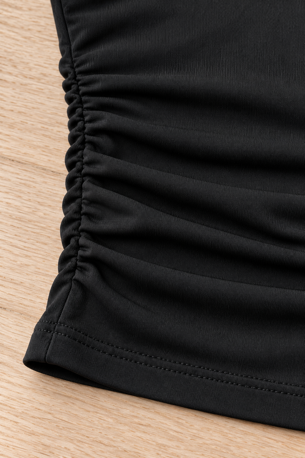 CRAMPFIT women's ruched yoga tube top in black, close-up of the side gathering, fabric texture and stitched hem.