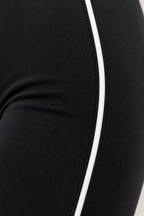 Close-up of CRAMPFIT black Sculpt Legging showing white contour piping, stitching and stretch fabric texture.