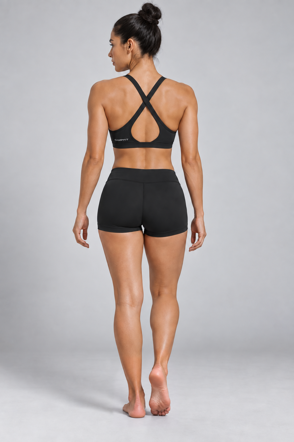 CRAMPFIT Women's Yoga Sports Bra - black back view, barefoot, styled with black workout shorts