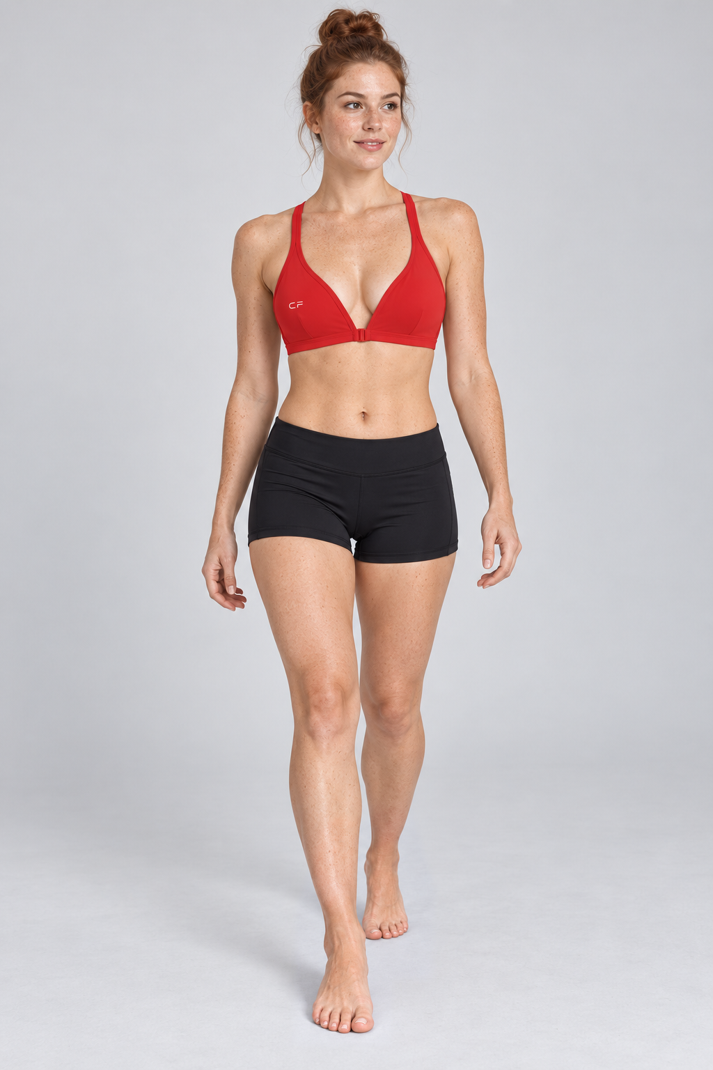CRAMPFIT Women's Yoga Sports Bra - red front view, barefoot, styled with black workout shorts